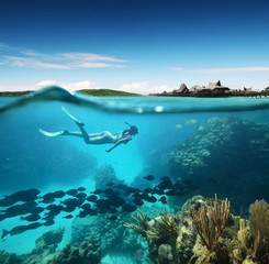 Young woman snorkeling in the coral reef in the tropical sea