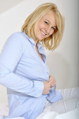 Naklejka premium Junge Frau knöpft Bluse