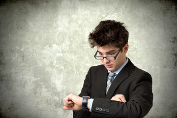 Young man looks at his watch