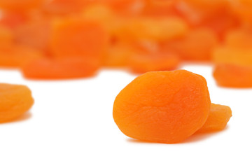 Scattered dried apricots on white background