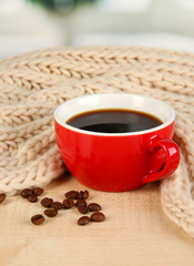 cup of coffee with scarf on table in room