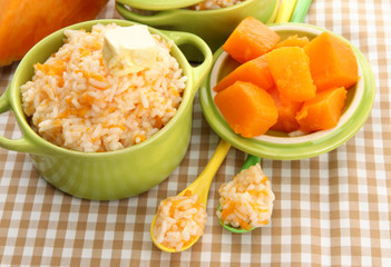 Taste rice porridge with pumpkin in saucepans