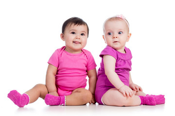 Funny babies girls sitting beside on floor