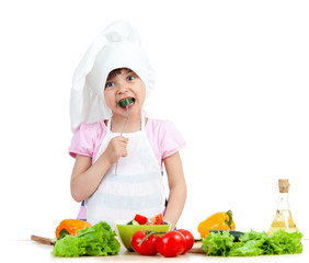 Chef kid preparing and tasting healthy food over white backgroun
