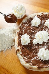 Italian Pizza, ingredients in the background on a wood table