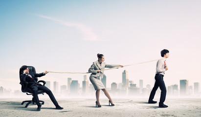 Three business people pulling rope