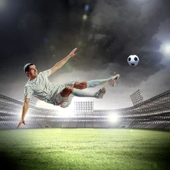 Foto op Canvas voetballer die de bal slaat © Sergey Nivens