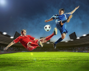two football players striking the ball