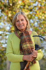 Woman raking leaves in a yard