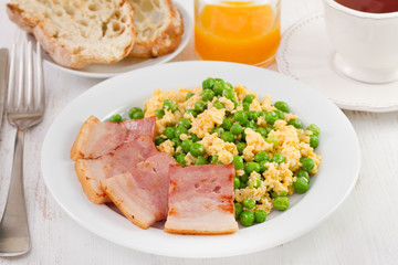scrambled eggs, peas and bacon with bread and juice