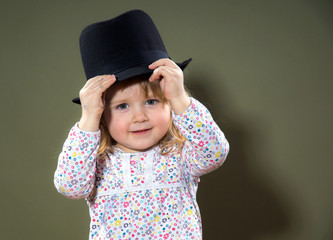 Cute little girl playing with hat