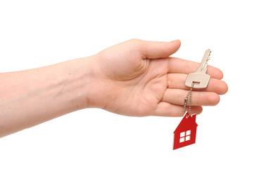 Hand holding key with a keychain in the shape of the house on th