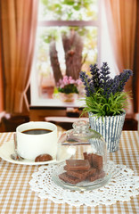 Chocolate pieces under glass cover and hot drink