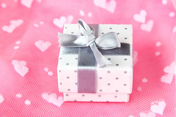 Color gift box with silver ribbon, on color background