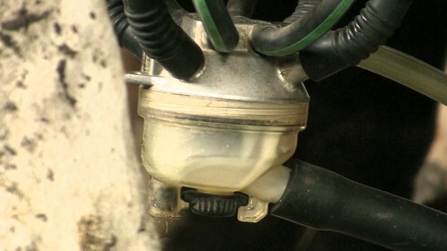 Closeup of a milking machine extracting milk from a cow's udder