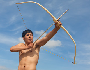 A young man shoots a bow