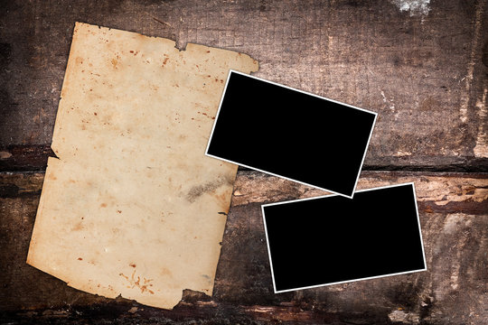 Aged photo frames and aged paper on wood