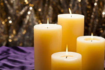 Obraz na płótnie Canvas Four candles over purple velvet
