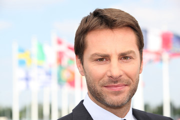 Man stood in front of flags