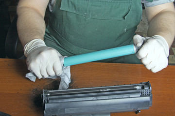 hands repairing laser toner cartridge