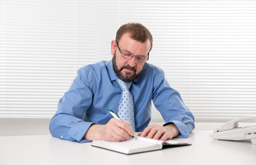 Fototapeta premium businessman makes a note in notebook