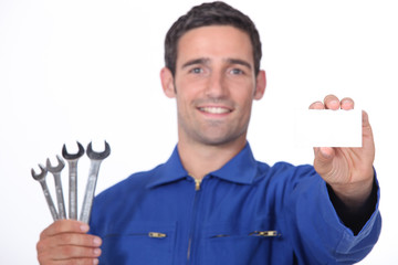 Mechanic holding selection of spanners and business card - Powered by Adobe
