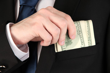 Money in pocket of businessman close-up