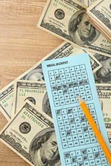 Lottery ticket,money and pencil on wooden background