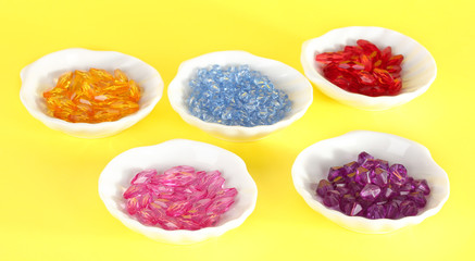 Beads in plates on yellow background