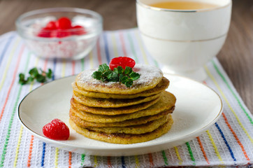 A stack of pancakes with cherry and mint