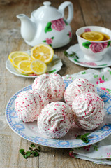 Marshmallow on a plate on a wooden table with the tea