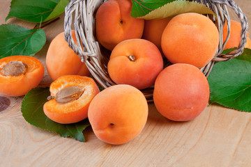 fresh apricots with leaves on wooden background