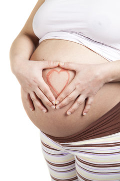 Pregnant woman making heart shape with hands over her stomach