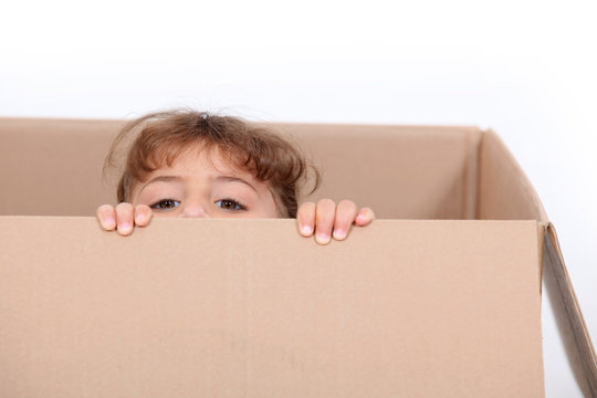 little girl hiding in a cardboard