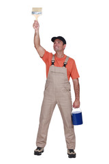 Happy tradesman painting a wall
