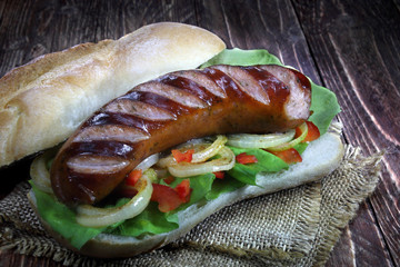 Fried sausage with bread roll, lettuce, onions and paprika