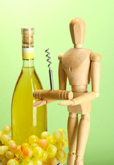 Mannequin with corkscrew and wine bottle, on green background
