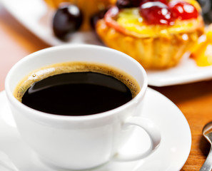 Cup of coffee and sweet fruit cake on a table