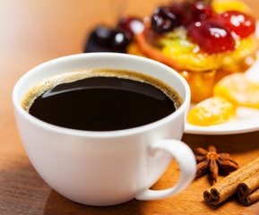 Cup of coffee and sweet fruit cake on a table