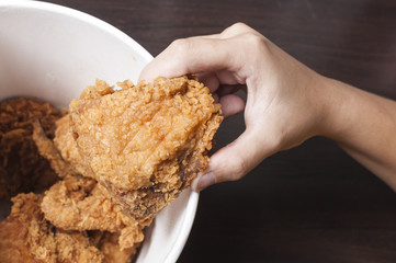 hand picking up fried chicken