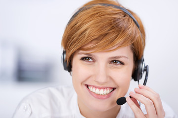 lächelnde mitarbeiterin telefoniert mit headset