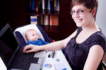 business woman working on a laptop with her baby