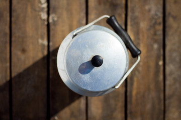 retro milk can with wooden background - top view