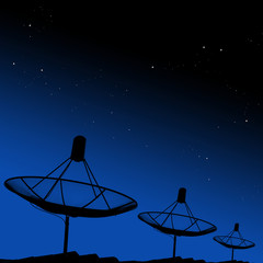 Satellite dishes on rooftop with night sky