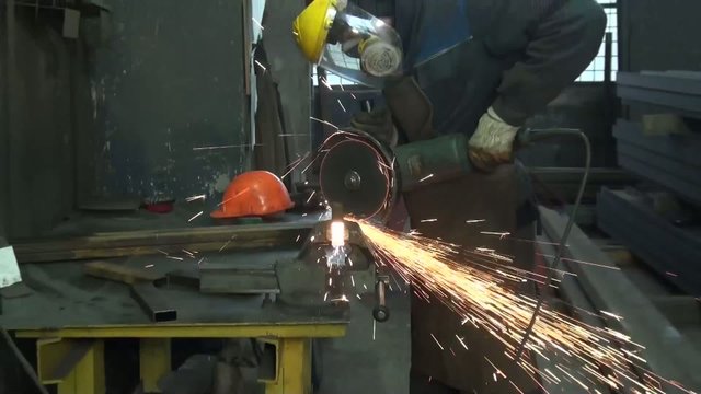 man in a mask metallic profile circular saw cuts