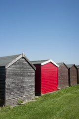 Fototapeta na wymiar A bright red painted beach hut at Dovercourt, Essex, UK.