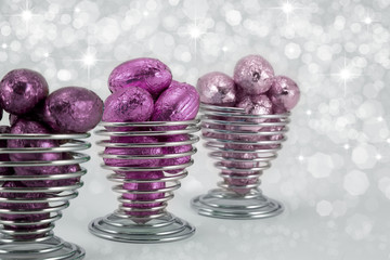 Pink easter eggs in wire eggcups.
