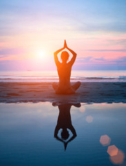 Silhouette d& 39 une femme yoga sur mer coucher de soleil avec réflexion.