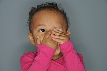 mixed race girl covering one eye with her hands