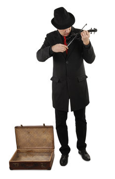 Street musician with violin and open old suitcase